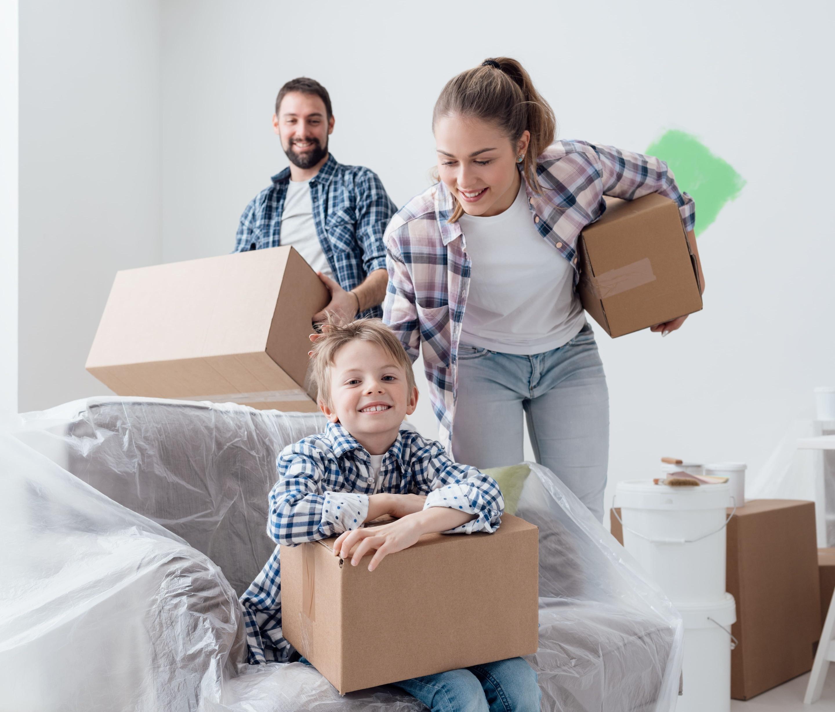 A person checking items off a moving checklist with packed boxes in the background